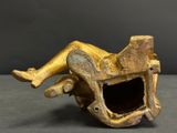 an antique bronze figurine of a woman laying on a chair