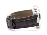 a black watch with red stitching on the strap