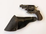 un petit revolver posé sur une surface blanche