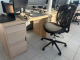 a desk with a computer and a chair in front of it