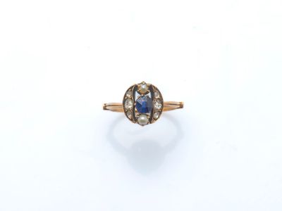 gros plan d'une bague en or avec un saphir et des diamants