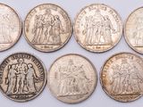 six different types of silver coins on a white surface