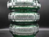 a stack of green glass containers sitting on a table
