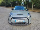 a grey mini cooper parked on the side of the road