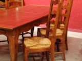 a wooden table and chairs in a room with a red wall