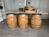 two wooden barrels sitting on a table with a basket on top