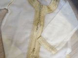 a white shirt with a yellow trim on it on the floor