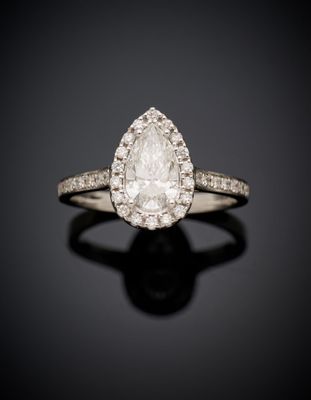 a pear shaped diamond ring with diamonds on a black surface