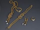three pieces of jewelry including a gold chain, a ring, and a pair of earrings