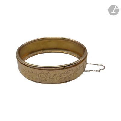 un gros plan sur un bracelet en or entouré d'une chaîne