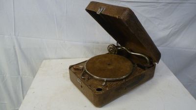 an old record player sitting on top of a white table