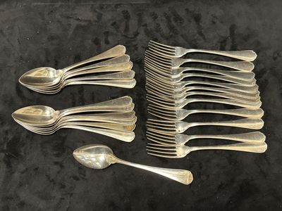 Plusieurs cuillères en argent et cuillères-cuillères sont alignées sur une surface noire