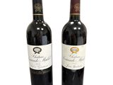 deux bouteilles de vin rouge posées l'une à côté de l'autre sur une surface blanche
