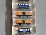 six petits trains dans une boîte en plastique posée sur une table