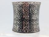 a close up of a silver cuff bracelet on a white surface