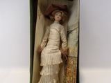 une vieille poupée dans une boîte, avec une robe et un chapeau