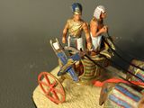 a figurine of two people riding in a horse drawn carriage