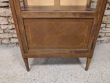 an old wooden cabinet with a glass door on it