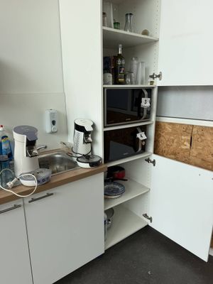 a small kitchen with a microwave, sink, and cabinets