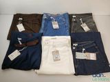 Cinq paires de jeans pour homme sont disposées sur une table