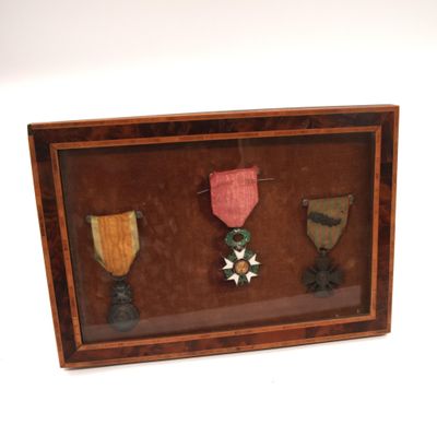 une photo d'un cadre-vitrine contenant trois médailles