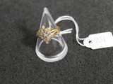 une bague en or posée sur un cône transparent, avec une étiquette de prix