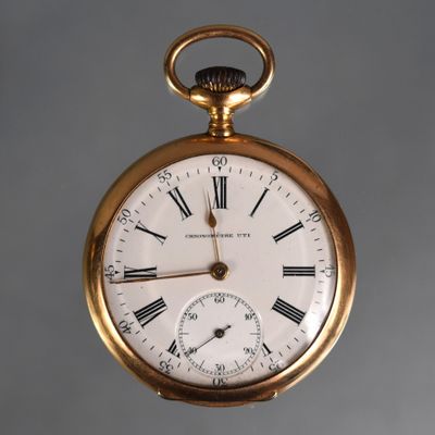 a gold pocket watch with roman numerals on the face