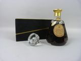 une image représentant une bouteille de brandy à côté d'un bouchon en verre