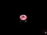 un diamant rose dans l'obscurité, sur fond noir