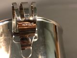 a silver cup with a ring on it sitting on a table