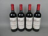 three bottles of red wine are lined up on a table
