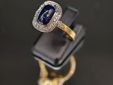 un gros plan d'une bague sertie d'un saphir et de diamants