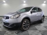 La Nissan QX-V argentée est garée sur un sol en carrelage à damier.
