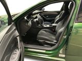 the interior of a green car with the door open and the driver ' s seat down