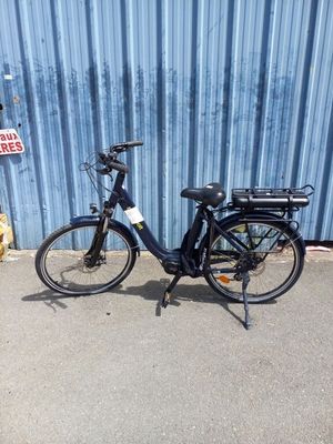 un vélo noir garé devant un mur bleu