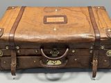 une valise marron posée sur une table blanche