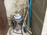 a metal canister sitting on the floor in the corner of a room