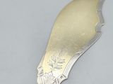 a silver spoon with a flower on it on a table