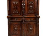 an oak cabinet with carved panels and carvings on the doors