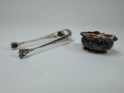 deux cuillères en argent et un repose-cuillère posés sur une surface blanche