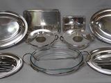 de nombreuses assiettes et casseroles en argent posées sur une table
