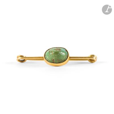 a close up of a green stone broochle on a white background