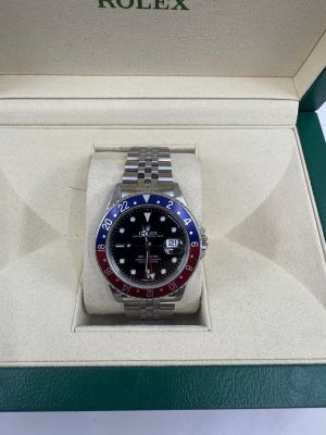 une montre Rolex dans son coffret, posée sur une table