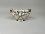 an image of a white bowl with gold handles on a white surface