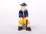 a figurine of a man sitting on a bench