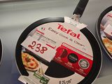 trois poêles exposées dans un magasin, avec leurs étiquettes de prix