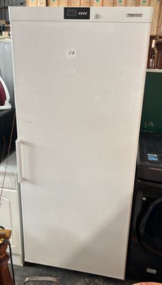 a white refrigerator sitting in the middle of a room
