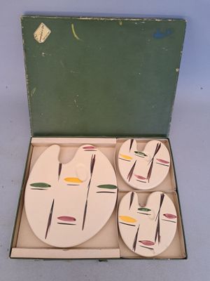 four coasters in a box with a design on them