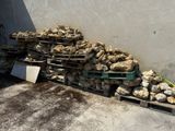 un tas de pierres posé sur une palette près d'un mur