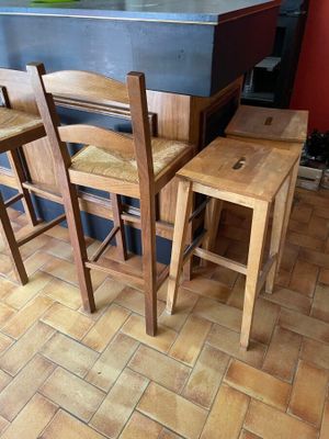 trois chaises en bois posées au comptoir de la cuisine